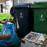 Man recycling paper, glass, plastic, cans and other rubbish in different containers, Belgium